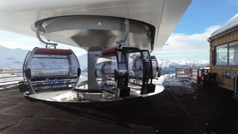 People-get-off-and-take-their-ski-equipment-from-the-cable-car's-side-compartment-to-exit-the-terminal-in-Vogel,-Slovenia