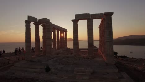 Luftaufnahme-Des-Poseidon-Tempels-Bei-Sonnenuntergang-Zur-Goldenen-Stunde,-Reiseziel-Sounion,-Griechenland