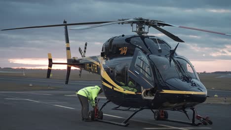 The-pilot,-along-with-airport-staff,-conducts-maintenance-on-a-Bell-429-helicopter-at-Vaclav-Havel-Airport-in-Prague