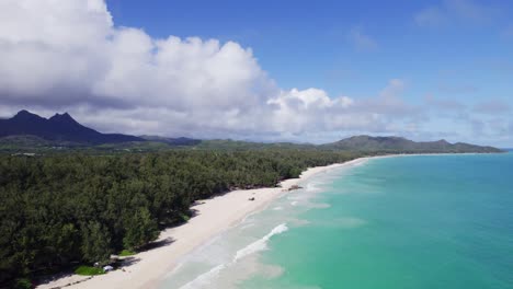 descending-drone-footage-from-deep-purple-mountains-and-lush-greenery-to-sandy-white-beaches-and-turquoise-water-of-Waimanalo-Bay-Oahu-Hawaii-paradise