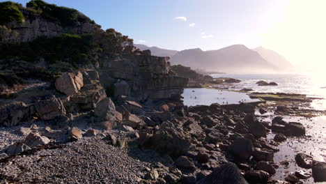 Sonnenaufgangsdrohne-In-Richtung-Hermanus-Marine-Pool-Mit-Menschen,-Die-In-Kaltes-Wasser-Eintauchen