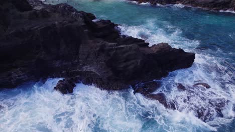 Aufsteigende-Drohnenaufnahmen-Von-Starken-Wellen,-Die-Heftig-Gegen-Eine-Felsklippe-Auf-Oahu,-Hawaii,-Schlagen