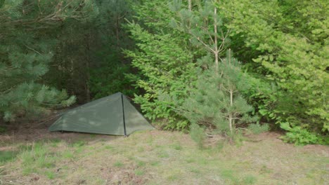 Panning-from-the-left-to-the-right-side-of-the-frame-showing-a-tent-in-a-campground-in-the-middle-of-Thetford-Forest,-in-United-Kingdom