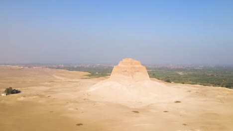 An-aerial-view-reveals-the-desert-landscape-featuring-the-Pyramid-of-Djoser,-renowned-as-the-Step-Pyramid-of-Djoser,-an-archaeological-wonder-situated-within-the-Saqqara-necropolis-in-Giza,-Egypt