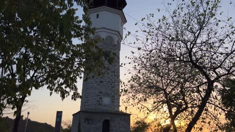 Tilt-down-on-Sahat-Tepe-clock-tower-at-sunset,-Plovdiv,-Bulgaria