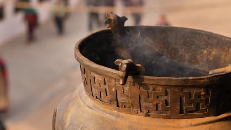 Close-shot-of-small-bowl-with-burning-incense,-Boudhanath-Temple,-Kathmandu,-Nepal