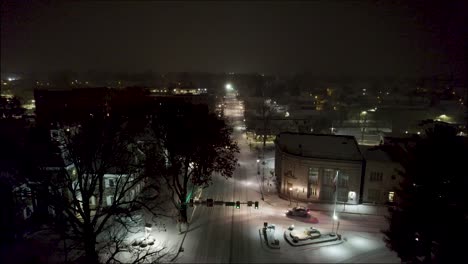 Aerial-shot-above-a-snowy-road-in-downtown-Lititz-at-night,-going-north