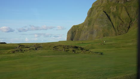 Picturesque-Landscape-of-Heimaey-Island,-iceland-on-Sunny-Summer-Day,-Green-Pasture-and-Volcanic-Cliffs