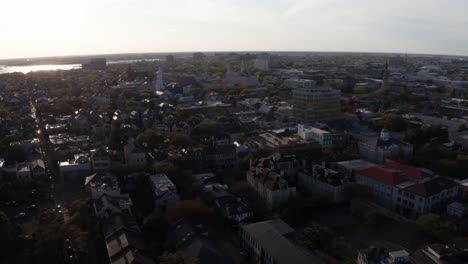 Aerial-wide-panning-shot-of-the-historic-French-Quarter-during-sunset-in-Charleston,-South-Carolina