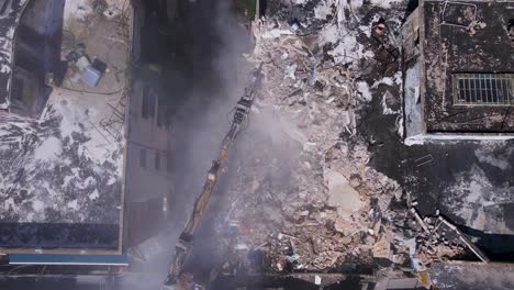 Top-shot-of-Bulldozer-clears-the-rubble-of-collapsed-buildings-in-the-on-David-Bloch-street,-Tel-Aviv,-Israel