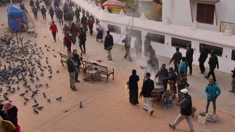 Medium-shot-of-people-walking-around-the-outer-section-of-Boudhanath-Temple,-Kathmandu,-Nepal