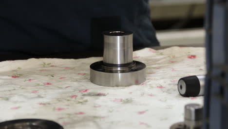 close-up-of-technician-hands-measuring-a-metal-product-with-precision-caliber-micrometer-on-workshop-table