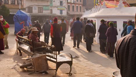 Ground-level-sunset-views-of-people-walking-around-the-outer-section-of-Boudhanath-Temple,-Kathmandu,-Nepal