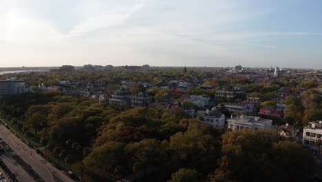 Wide-reverse-pullback-aerial-shot-of-White-Point-Garden-at-Oyster-Point-during-sunset-in-Charleston,-South-Carolina