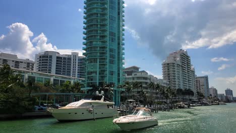 Bewegte-Aufnahme-Durch-Die-Wasserstraßen-Von-Miami-Mit-Schönen-Häusern-Und-Hochhäusern-Und-Yachten