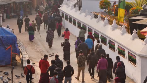 Vista-Elevada-De-Gente-Caminando-Alrededor-Del-Templo-Boudhanath-Al-Atardecer,-Katmandú,-Nepal