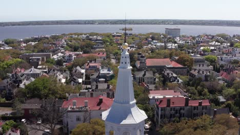 Aerial-parallax-panning-shot-of-the-spire-atop-Saint-Michael's-Church-in-the-historic-French-Quarter-of-Charleston,-South-Carolina
