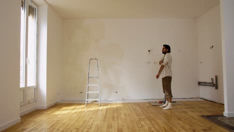 Un-Hombre-Dentro-De-La-Habitación-Vacía-Preparándose-Para-Pintar-Durante-La-Renovación