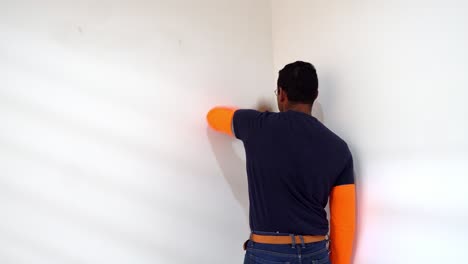 Pintor-Masculino-Limpiando-La-Pared-Antes-De-Pintar---Cerrar