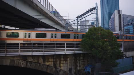 Tokyo-Train-on-JR-Line-Departing-Tokyo-Station-with-City-Background-4k