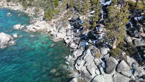 Aerial-view-or-large-boulders-on-crystal-clear-Lake-Tahoe-beach,-California