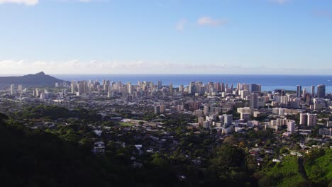 Drohnenaufnahme-Mit-Schwenk-Nach-Links-über-Die-Stadt-Honolulu-Hawaii-Mit-Dem-Pazifischen-Ozean-Im-Hintergrund-Und-Blauem-Himmel-Von-Einem-Aussichtspunkt-In-Den-Bergen-Auf-Oahu