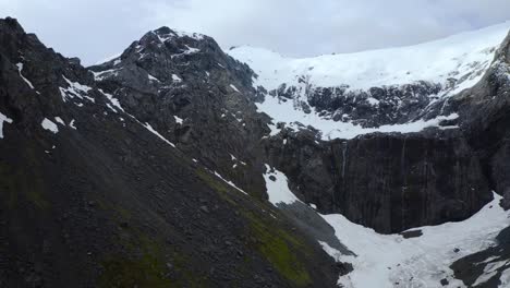 Entspannter-Abstieg-Vom-Berggipfel-Zum-Gletschertal-In-Fiordland,-Neuseeland,-Südinsel,-Schwenk-Nach-Rechts,-Luftaufnahme