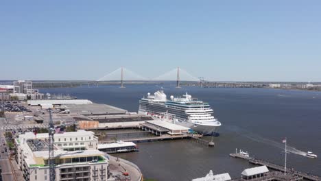 Niedrige-Luftaufnahme-Des-Kreuzfahrtterminals-Mit-Der-Ravenel-Bridge-In-Der-Ferne-In-Charleston,-South-Carolina