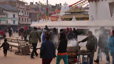 Plano-Medio-A-Nivel-Del-Suelo-De-Personas-Caminando-Por-La-Parte-Exterior-Del-Templo-Boudhanath,-Katmandú,-Nepal.