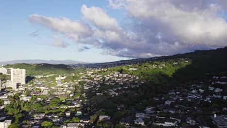 Toma-Estática-De-Los-Suburbios-En-Las-Afueras-De-Honolulu,-Hawaii,-Con-Residencias-Construidas-A-Lo-Largo-De-La-Ladera-De-La-Montaña-Al-Final-De-La-Tarde-Y-Las-Nubes-Dan-Sombra-A-Parte-De-La-Ciudad.