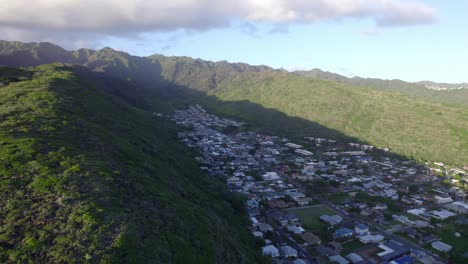Luftaufnahmen-Schwenken-Nach-Rechts-Und-Zeigen-Eine-Küstengemeinde-In-Honolulu,-Hawaii,-Eingebettet-Zwischen-Den-Bergen-Und-Dem-Pazifischen-Ozean