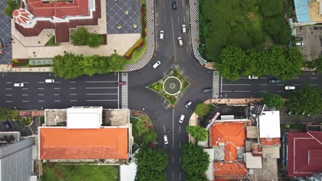 Der-Geschäftige-Verkehr-Fließt-An-Der-Kreuzung-In-Surabaya,-Flankiert-Von-Alten-Gebäuden-Im-Kolonialstil-Und-Grünflächen-Neben-Fußgängerzonen