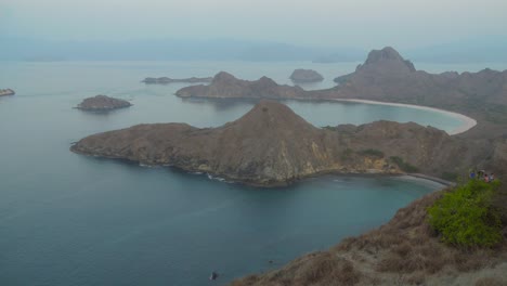 Impresionante-Vista-Desde-La-Isla-Padar-De-Playa-Rosa-Y-Montañas-En-Un-Día-Brumoso-Durante-El-Crepúsculo-En-Indonesia