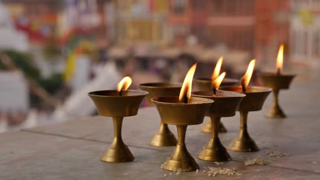 Close-shot-of-burning-butter-lamps,-Boudhanath-Temple,-Kathmandu,-Nepal