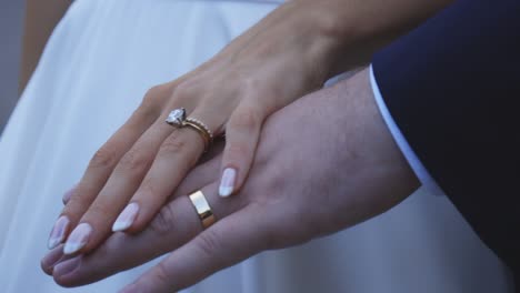 Bride-and-groom-rest-hands-during-sunset
