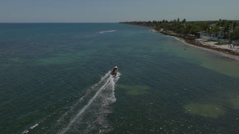 Boats-navigating-along-Guayacanes-Beach,-San-Pedro-de-Macoris-in-Dominican-Republic