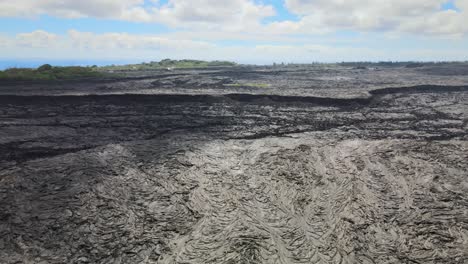 Drone-pans,-revealing-vast-scale-of-lava-fields-on-Big-Island,-Hawaii,-from-Leilani-Estates