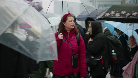 Mujer-Con-Paraguas-De-Pie-En-Medio-De-La-Multitud-Cruzando-La-Calle-En-Shibuya.