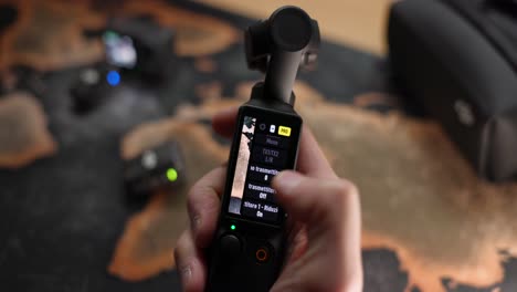 Hand-holding-the-DJI-Osmo-Pocket-3-and-navigating-menu-to-connect-wireless-microphone