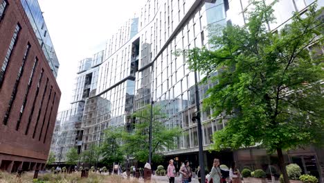 Observing-the-mixed-use-residential-and-business-development-buildings-at-Battersea-Power-Station,-London,-showcasing-a-modern-architectural-style-with-a-pedestrian-area-in-the-foreground