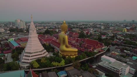 Aerial-rotation-capturing-the-Royal-Wat-Paknam-Phasi-Charoen-temple,-located-on-the-outskirts-of-Bangkok,-featuring-a-towering-69-meter-Buddha-statue