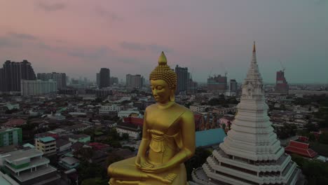 Aerial-capturing-the-majestic-Royal-Wat-Paknam-Phasi-Charoen-temple,-situated-on-the-outskirts-of-Bangkok,-showcasing-a-towering-69-meter-Buddha-statue