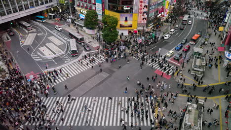 Große-Menschenmenge-Von-Fußgängern-Und-Verkehr-An-Der-Shibuya-Kreuzung-In-Tokio,-Japan