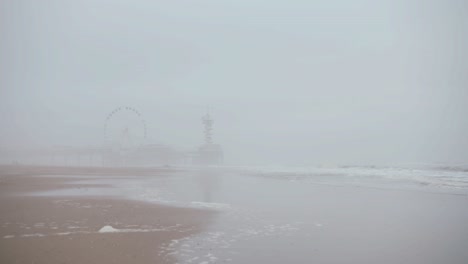 View-of-an-amusement-park-next-to-the-ocean,-during-a-super-foggy-day-in-Den-Haag