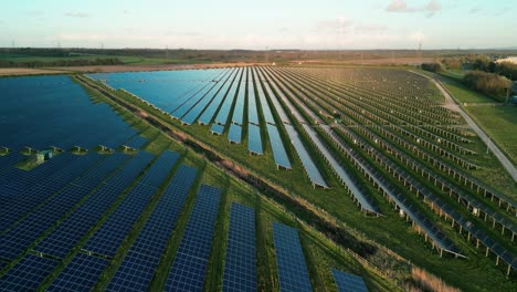 Shotton-Solar-farm---geometrical-panels,-illuminated-at-dusk,-aerial-drone-slow-anti-clockwise-rotate,-North-Wales,-UK
