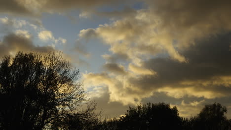 Evening-sunlight-illuminates-storm-clouds-as-they-gather-over-Worcestershire,-England-at-dusk-in-a-Timelapse-on-a-windy-day