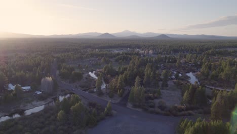 Ascending-drone-shot-pulls-out,-framing-the-Three-Sisters-in-Bend,-Oregon,-with-a-sunset-glow