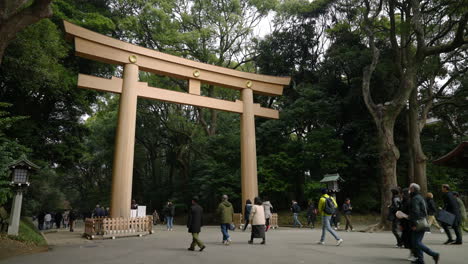 Gente-Caminando-Por-Torii-En-La-Entrada-Del-Santuario-Meiji-Jingu-En-Tokio,-Japón,-Temprano-En-La-Mañana