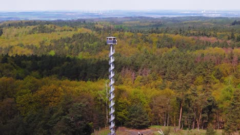 Firefighter-observation-tower-between-forests,-aerial-parallax-view