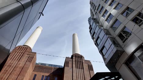 Ein-Blick-Nach-Oben-Auf-Die-Berühmten-Schornsteine-Des-Kraftwerks-Battersea-In-London,-Das-Moderne-Architektonische-Meisterleistung-Mit-Seiner-Rolle-Als-Energieanlage-Verbindet